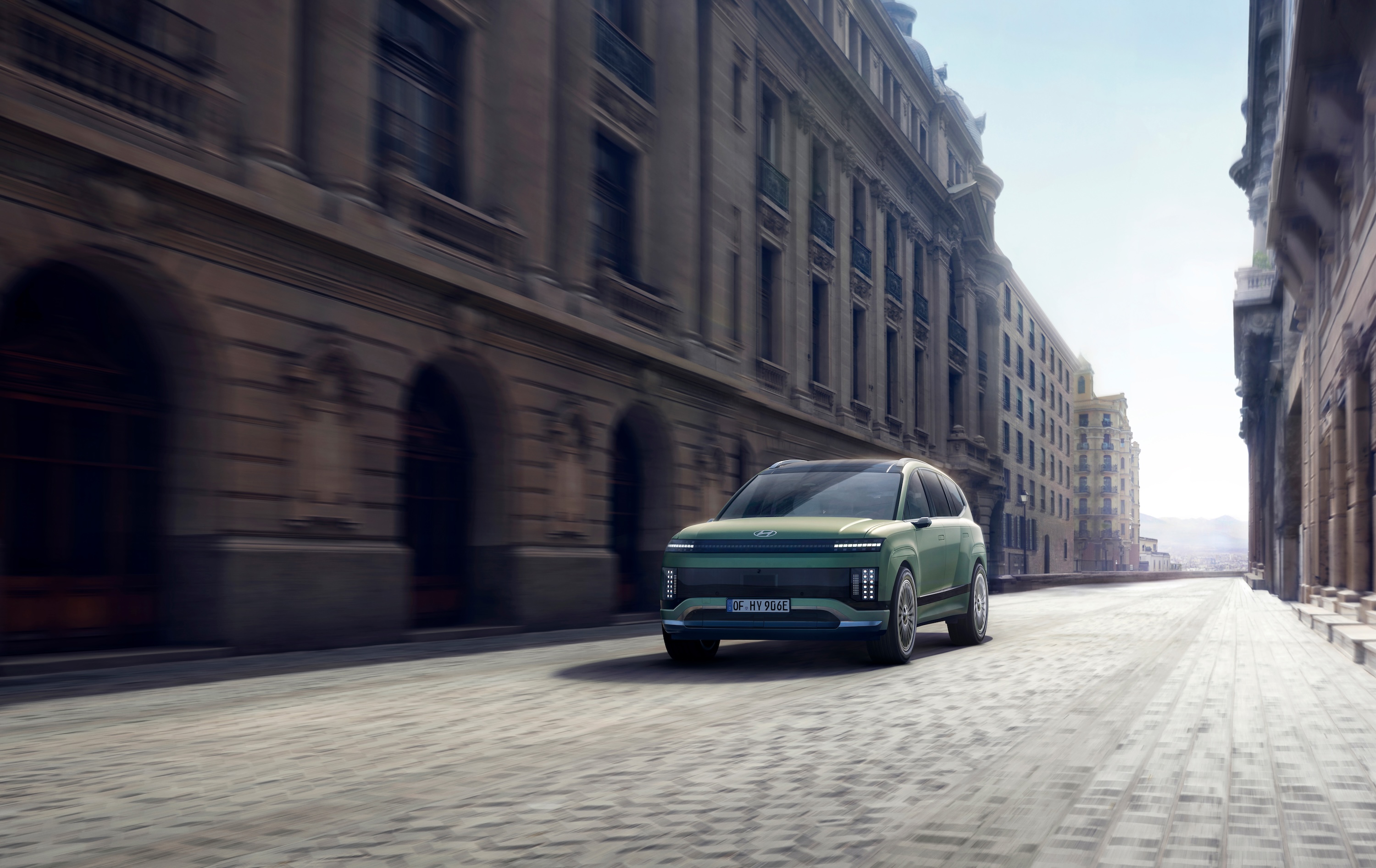 Three-quarter view of the new Hyundai IONIQ 9 driving in the city.