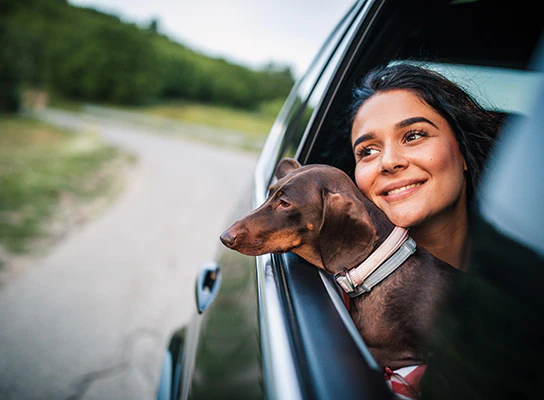 Woman holding dog in car